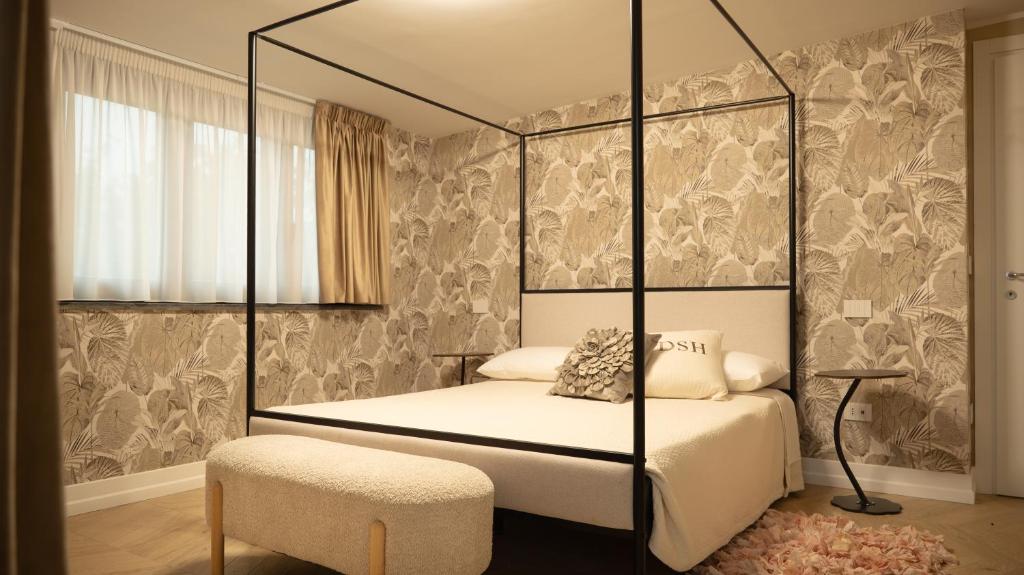 Suite Parigi con letto a baldacchino in metallo nero, carta da parati botanica e panca imbottita